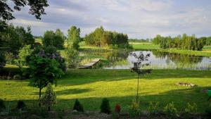 a view of a lake with a dock in the grass at Agroturystyka Mazury Cicha Wólka in Zawady
