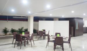 a conference room with tables and chairs and a projection screen at Treebo Trend Celeste in Visakhapatnam
