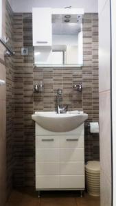 een badkamer met een wastafel en een spiegel bij Divna Guest House in Krushuna