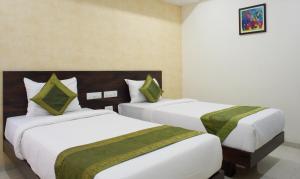 a hotel room with two beds with green sheets at Treebo Trend Celeste in Visakhapatnam