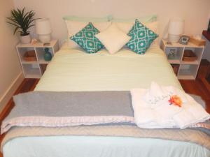 a bed with towels and pillows on top of it at Riverbend Suite Rooms in Rosebank