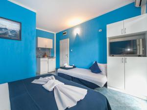 Apartments MIK5 في بودفا: غرفة بسريرين وجدار ازرق