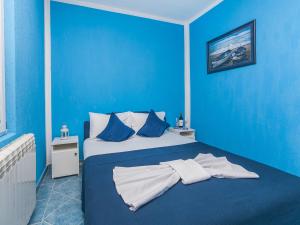 Apartments MIK5 في بودفا: غرفة نوم زرقاء مع سرير بجدران زرقاء