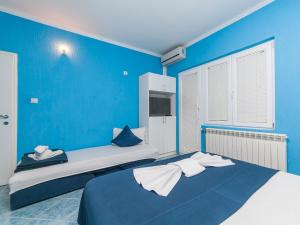 Apartments MIK5 في بودفا: غرفة نوم زرقاء بسريرين وجدار ازرق