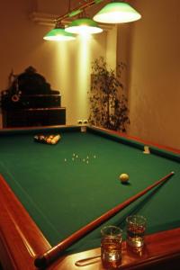 una mesa de billar verde con una pelota y dos vasos en Hotel Stelle Marine en Cannigione