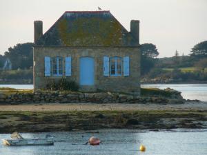 an old house on the shore of a body of water at Cook appartement in Étel