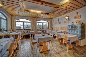 - un restaurant avec des tables et des chaises dans une salle dans l'établissement Berghof Pension und Ferienwohnungen, à Bischofsmais