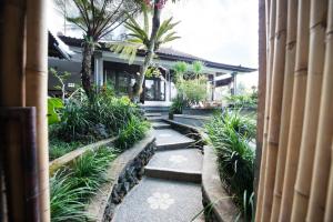 a walkway leading to a house with palm trees at Pondok Anastasia in Ubud
