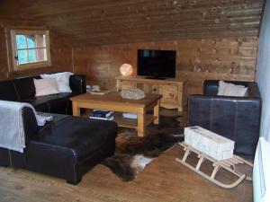 a living room with two couches and a tv at Chalet Odette in Morzine