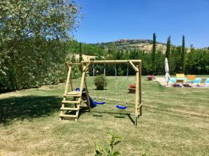 um parque infantil com uma escada e um baloiço num quintal em Agriturismo Marinello em Pienza