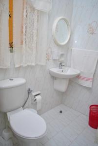 a white bathroom with a toilet and a sink at St Nicholas Crt in Munxar