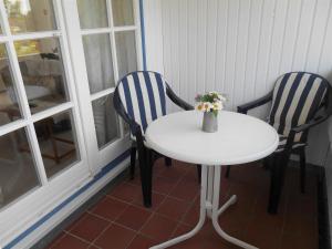ラーボエにあるFerienwohnung-Moltrecht-1の椅子2脚、花瓶付きテーブル1台