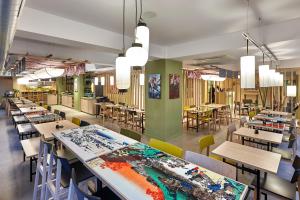 a dining room with tables and chairs and colorful walls at Yadoya Hotel in Brussels