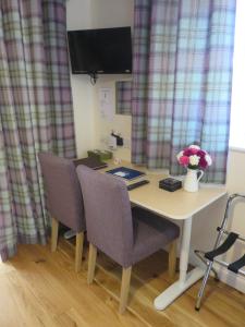 a desk with two chairs and a table with flowers on it at Apple Tree Corner Apartment in Yate