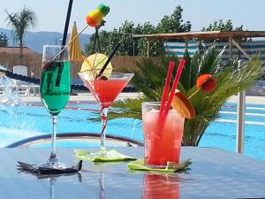 two drinks on a table next to a pool at Hotel Il Platano in Ottana
