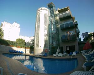 um edifício com piscina em frente a um edifício em Hotel TossaMar em Tossa de Mar
