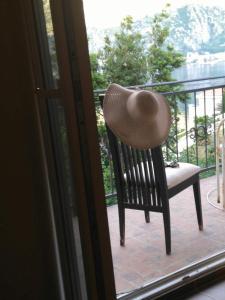 a straw hat sitting on a chair on a balcony at Apartmani Cuce in Kotor