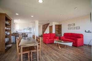 una sala de estar con sofás rojos y una mesa. en Alojamiento Turístico El Castro en La Revilla