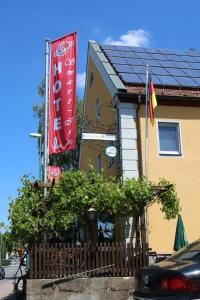 a building with a flag and a house with a fence at Hotel Smart-Inn in Erlangen