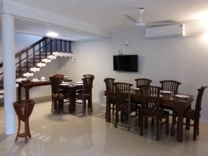ein Esszimmer mit einem Tisch und Stühlen sowie einem TV in der Unterkunft Colombo Residence in Colombo