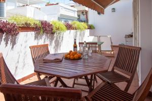 una mesa de madera con un bol de fruta en el balcón en Champion Duplex Terrace and Garage Old Town 6 pax, en Sevilla