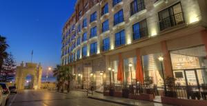 圣朱利安斯Vivaldi Hotel的城市街道上一座带钟楼建筑