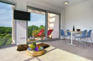 a living room with a table and chairs and a balcony at Premantura Resort - Hotel & Restaurant in Premantura