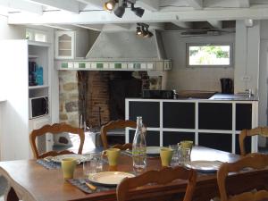 a dining room table with chairs and a kitchen at Le Moulin de l'Abbé in Sorèze