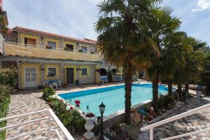a house with a swimming pool and palm trees at Apartments Paradis in Rovinj