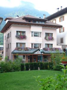 a large white building with flower boxes on it at Appartements Tlusel in Ortisei