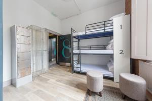 ロンドンにあるパブローブ アット ザ グリーン マン パディントンの二段ベッドと椅子2脚が備わる客室です。