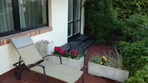 グディニャにあるMirka Apartmentの花と植物のあるパティオ(椅子付)