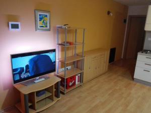 a living room with a tv and a table with a desk at Apartment Štinjan Kaščuni in Pula