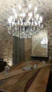 a chandelier in a room with a wooden table at Iblainsuite in Ragusa