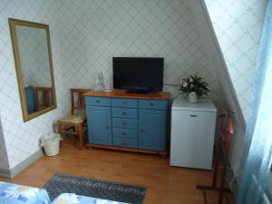 a blue dresser with a television on top of it at Mäntyluodon Hotelli in Pori