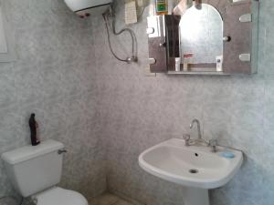 a bathroom with a toilet and a sink and a mirror at El Manal 1 Private Apartment in Ain Sokhna