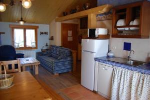 a kitchen and living room with a refrigerator and a couch at Casa Lueza in Alueza