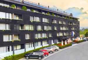 a row of cars parked in front of a building at Lucky Bansko Aparthotel SPA & Relax in Bansko