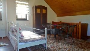 a bedroom with a bed and chairs and a table at Apartment Holiday - River view beside Pyramid in Visoko