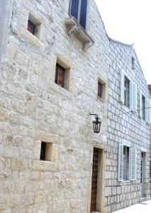 a stone building with windows and a street light at Holiday Home Lija Center in Rab