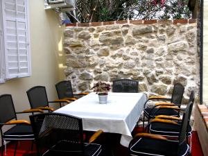 a table and chairs in a room with a stone wall at Holiday Home Lija Center in Rab