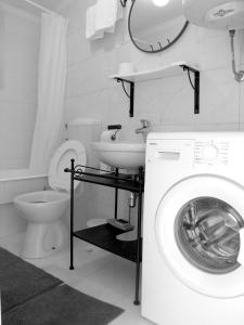 een badkamer met een wasmachine en een wastafel bij Holiday Home Lija Center in Rab