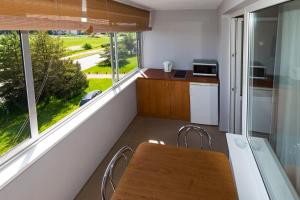 una piccola cucina con tavolo e finestra di Pas Roma a Šventoji