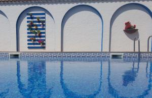 un edificio con piscina con pared en Hotel Mediterrani Express, en Calella