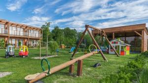 a park with a playground with a swing at Domki Apartamentowe Bueno in Dąbki
