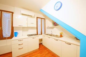 a kitchen with white cabinets and a blue staircase at DolceVita Apartments N 382 in Venice