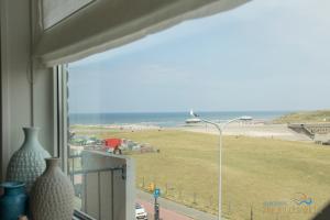 Katwijk aan ZeeにあるAppartement Zee en Duinzicht 84の通りの光が差し込む窓からビーチの景色を望めます。