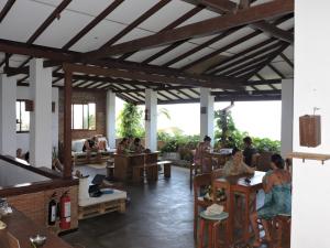 a group of people sitting at tables in a restaurant at Bay Vista in Arugam Bay
