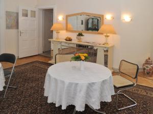 a room with a table with a vase of flowers on it at Pension Brinn in Berlin