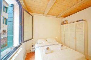 ヴェネツィアにあるDolceVita Apartments N 181のベッドと大きな窓のある寝室 +9枚の写真